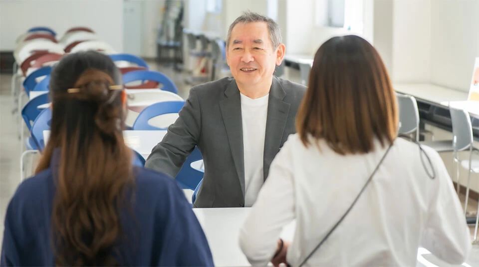 保護者説明会を女性と保護者が受けている