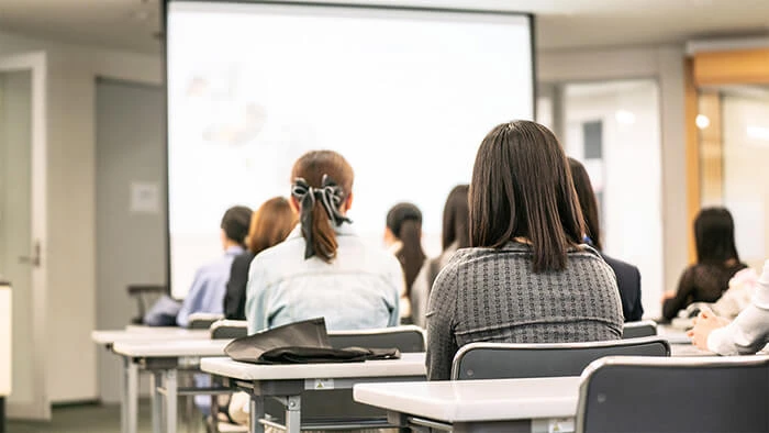 女性や保護者が山野美容芸術短期大学のオープンキャンパスの説明を受けている。