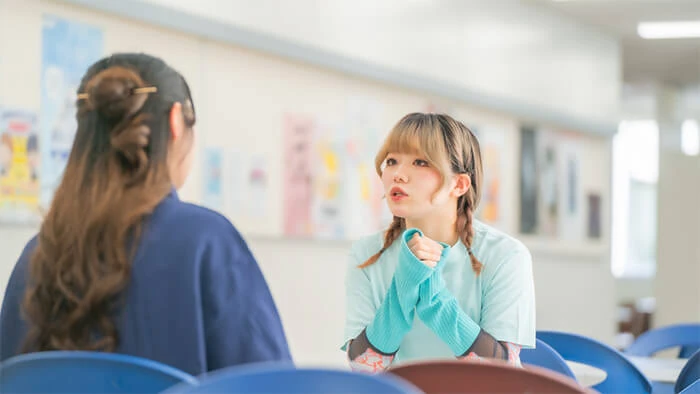 山野美容芸術短期大学のオープンキャンパススタッフが女性と個別相談をしている